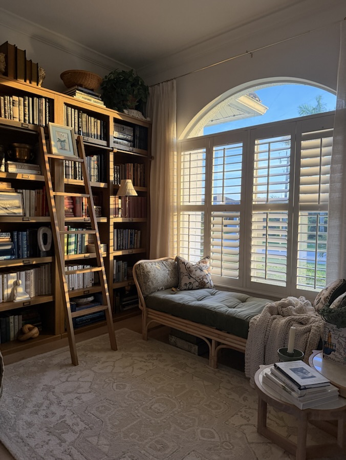 Den with built-in bookshelves and a library ladder